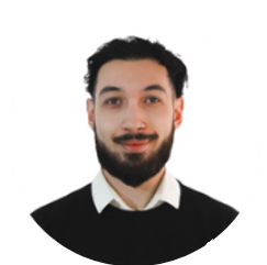 Miembro del equipo sonriendo con barba y camisa, Nuestro Equipo.